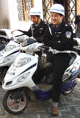 Chinesische Polizisten auf Elektro-Motorrollern